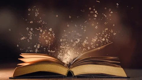 A hardcover book open, lying flat on a surface. Light seems to be coming from the pages.